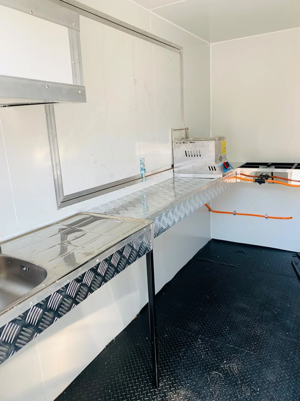 Mobile kitchen interior with metal worktops, sink, and cooking area