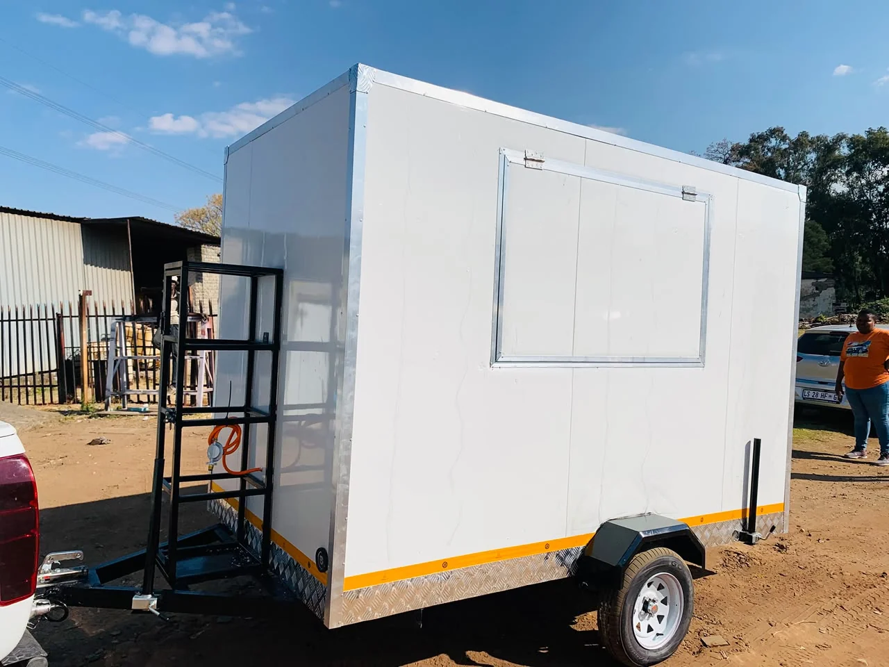 White mobile trailer with a serving hatch and steel frame